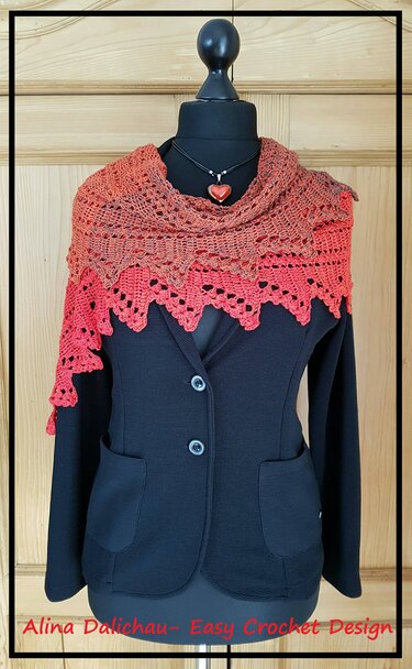 Gehäkelter Dreiecksschal in Koralle-Orange mit gezacktem Spitzenrand auf einer Schneiderpuppe über schwarzem Blazer