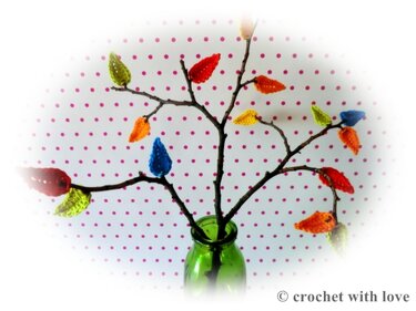 Zweig-Arrangement in grüner Vase mit kleinen gehäkelten Blatt-Applikationen in Rot, Orange, Gelb, Grün und Blau