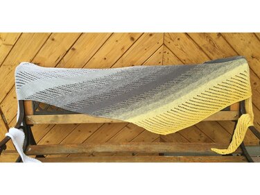 Asymmetrisches gestricktes Dreieckstuch mit Farbverlauf Hellgrau
Grau
Gelb, drapiert über einer Holzbank