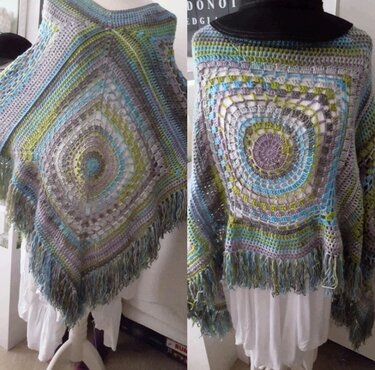 Gehäkelter Damenponcho mit zentralem Quadratmuster und Fransen in Grau, Blau, Grün und Lila auf Schaufensterpuppe