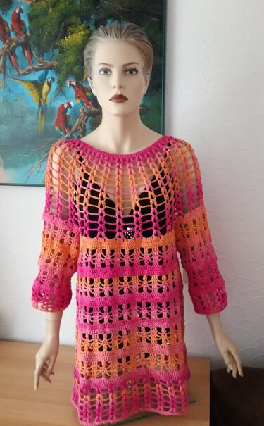 Mannequin trägt gehäkelte Damen-Tunika in Pink-Orange mit Ajourstreifen und Dreiviertelärmeln