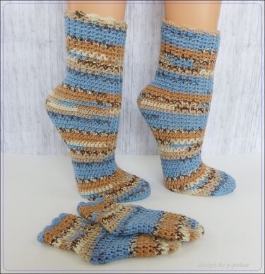 Gestreifte, wadenlange Socken aus gehäkeltem Garn auf Modellbeinen mit zusätzlichem Paar flach liegend