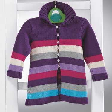 Gestrickte Kinderjacke mit horizontalen Streifen in Lila, Pink, Grau, Creme und Türkis, aufgehängt an einem Bügel.