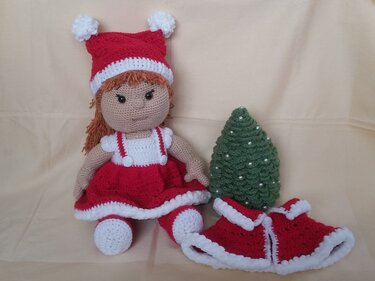 Gehäkelte Puppe in rotem Weihnachtskleid mit Bommelmütze, grüner Häkel-Tannenbaum und roter Umhang