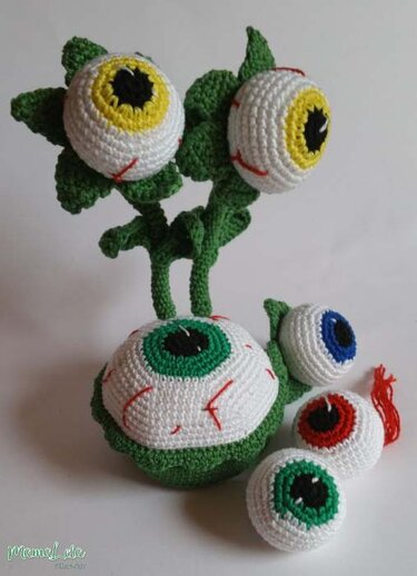 Skulptur aus gehäkelten Kugelaugen mit grünen Stielen und losen Augen