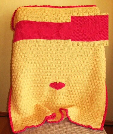 Gestrickte Babydecke gelb mit rotem Streifen, Herzmotiv und gewelltem Rand