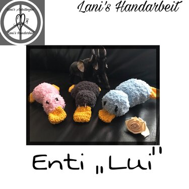 Drei gehäkelte Amigurumi-Enten in Rosa, Braun und Hellblau mit gelbem Schnabel