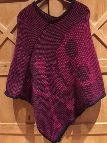 Zweifarbiger gestrickter Damenponcho in Magenta mit dunklem Totenkopf-Motiv und kontrastfarbener Kante