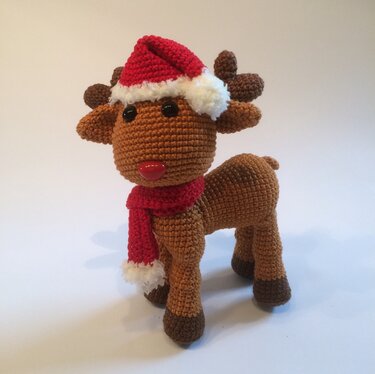 Amigurumi-Rentier in Braun mit roter Mütze, Schal und dunkleren Hufen