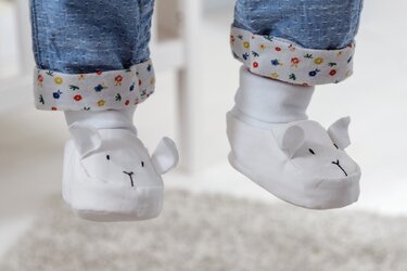 Weiße, verschlussfreie Babyschuhe mit angenähten Ohren und gesticktem Gesicht