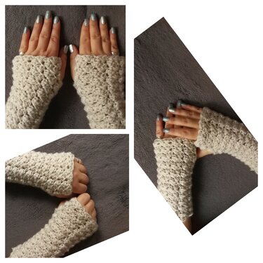 Beige gehäkelte fingerlose Handschuhe mit strukturiertem Muster auf grauem Hintergrund, getragen von Händen mit silbernem Nagellack.