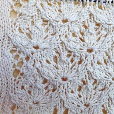 Cremefarbenes Strickmuster mit Fächer-Lochstruktur