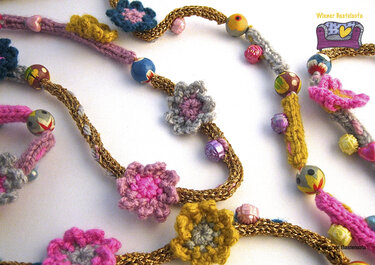 Bunte gehäkelte Kette mit kleinen Häkelblüten, farbigen Perlen und goldfarbenem Zopf.