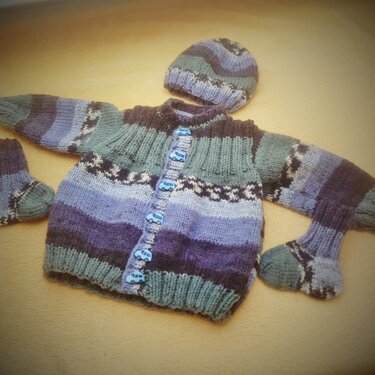 Gestricktes Baby-Set in Blau-, Grün- und Lilatönen mit Cardigan, Mütze und Socken sowie Autoknöpfen