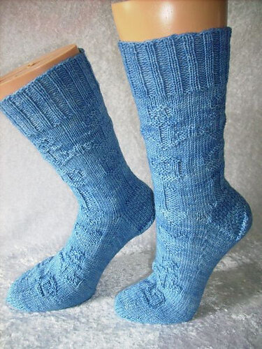 Himmelblaue gestrickte Socken mit Rippenbündchen auf Strumpfspannern.