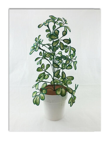 Gehäkelte Zimmerpflanze mit vielen kleinen grünen Blättern in einfachem weißen Topf vor hellem Hintergrund.