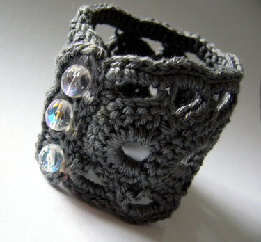 Dark gray crocheted cuff bracelet with three clear faceted beads
