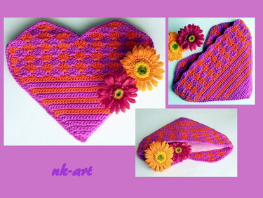 Gehäkelter herzförmiger Topflappen in Pink und Orange mit Muschelmuster, dekoriert mit Blumen