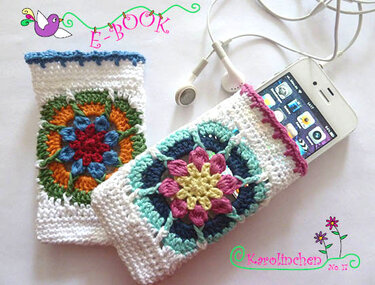 Zwei weiße gehäkelte Handytaschen mit bunten Granny-Square-Motiven, eine enthält ein Smartphone.