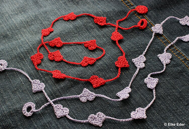 Rote und lila Herzgirlanden auf Jeansstoff