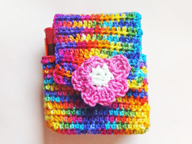 Buntes gehäkeltes Mini-Utensilo mit rosa Blüte