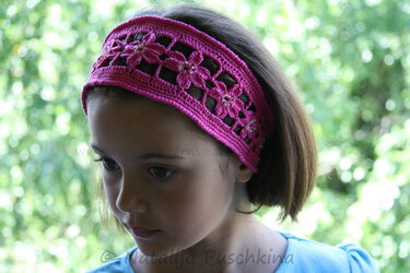 Kind mit pinkem gehäkeltem Stirnband und Blumenmuster