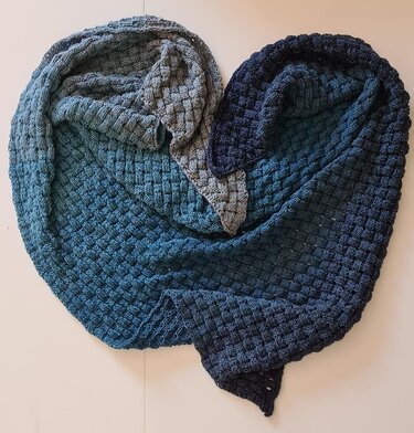 Gestricktes Dreieckstuch mit Waffelmuster in Grau-, Petrol- und Blautönen, drapiert in Herzform