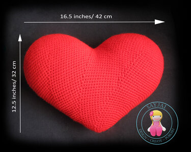 Red crocheted heart-shaped pillow on a dark background, 16.5 x 12.5 inches