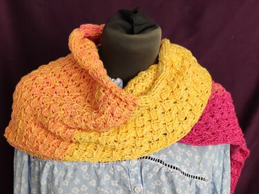 Mehrfarbiger gehäkelter Rundschal in Gelb, Orange und Pink auf Schaufensterpuppe