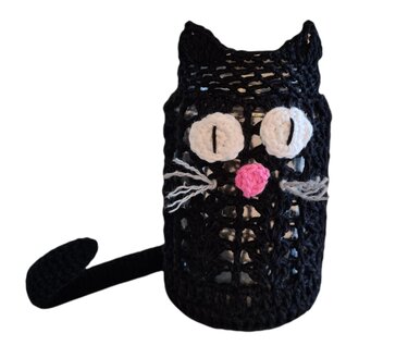 Zylindrische schwarz gehäkelte Katzenhülle mit Ohren, weißen Augen und rosa Nase