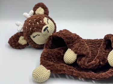Brown crocheted baby lovey with a deer head and cream crocheted corner paws