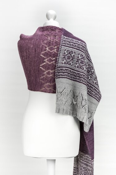 Rechtecktuch in Violett und Grau mit Loch- und Jacquardmustern, drapiert über eine weiße Schneiderpuppe.