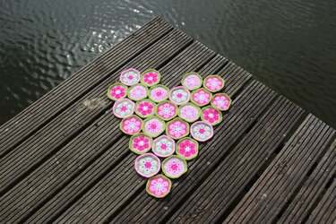 Herzform aus gehäkelten Afrikanischen‑Blumen‑Sechsecken auf Holzplanken