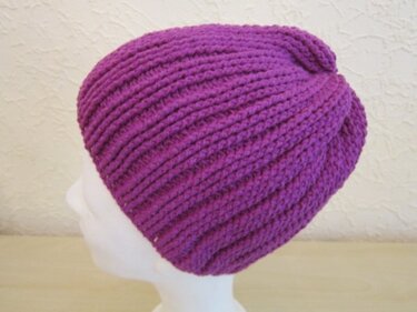 Lila, gerippte Häkelmütze im Turban-Stil — Seitenansicht auf weißem Schaufensterkopf