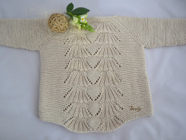 Gestrickter beiger Babypullover mit Muschelmuster auf der Vorderseite und langen Ärmeln