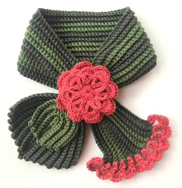 Gehäkelter Kragenschal grün-grau gestreift mit roter Blüte und Rüschensaum für Kinder.