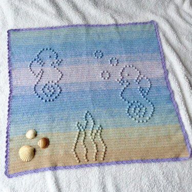Handgehäkelte Babydecke mit Seepferdchen-Relief, Pastellfarbverlauf und lila Rand