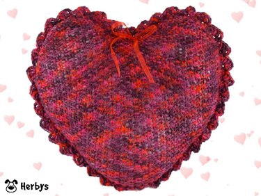 Romantisches gestricktes Herzkissen in Rot- und Pinktönen mit Muschelrand