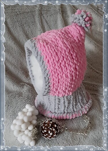 Gestrickte zweifarbige Kinder‑Schlupfmütze in Rosa und Grau mit Bommel auf grauem Plüschhintergrund