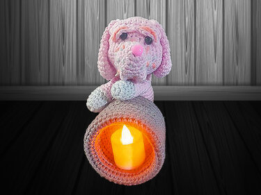 Rosa gehäkelter Amigurumi-Hund mit integriertem Kerzenhalter und leuchtendem Teelicht