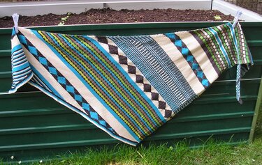 Detailreiches gestricktes Dreieckstuch mit Streifen- und Rautenmustern in Türkis, Grün, Schwarz und Creme