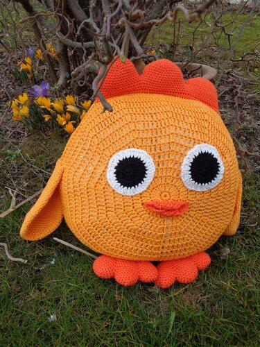 Gehäkeltes rundes Küken-Kissen in Orange mit großen Augen, orangefarbenem Kamm und kleinen Füßchen
