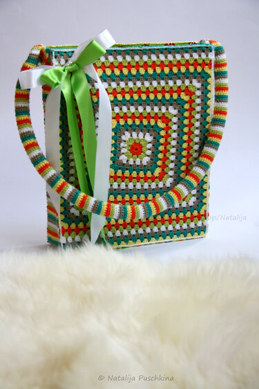 Bunte gehäkelte Umhängetasche im Granny-Square-Muster mit gestreiftem Schultergurt und Zierschleife