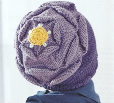 Lila gestrickte Babymütze mit strukturiertem Muster und gelber Schildkröten-Applikation