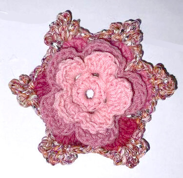 Mehrlagige rosa gehäkelte Blüten-Applikation mit gewelltem, mehrfarbigem Rand