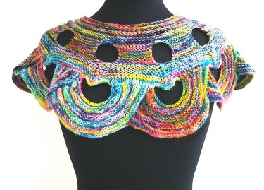 Bunter gestrickter Kragenschal mit runden und wellenförmigen Ausschnitten auf einer schwarzen Schneiderpuppe.