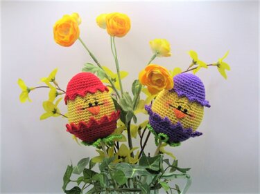 Gehäkelte Küken in gezackten Eierschalen auf Steckstäben als Osterstecker