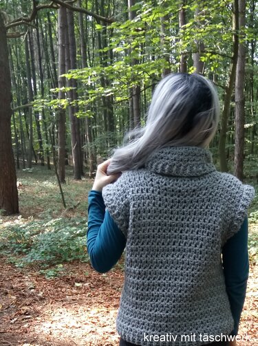 Rückenansicht: graue gehäkelte ärmellose Weste mit breitem Kragen