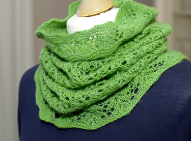 Grüner gestrickter Loop mit Ajourmuster auf Schaufensterpuppe