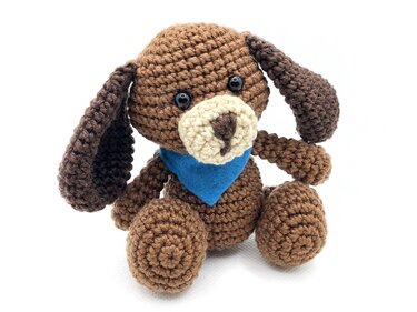 Gehäkelter brauner Amigurumi-Hund mit Schlappohren und blauem Halstuch